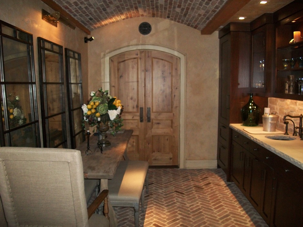 Immagine di un grande angolo bar con lavandino mediterraneo con lavello sottopiano, ante in stile shaker, ante in legno bruno, paraspruzzi grigio, paraspruzzi con piastrelle in pietra, pavimento in mattoni e pavimento rosso