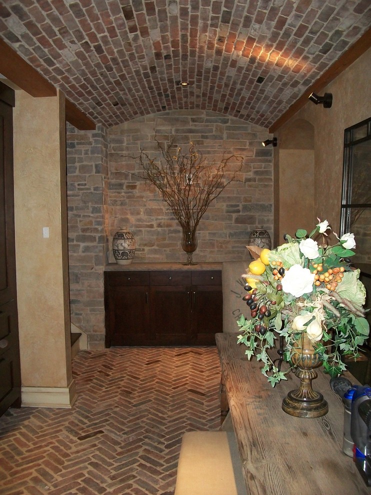 Cette photo montre un grand bar de salon avec évier linéaire méditerranéen en bois foncé avec un évier encastré, un placard à porte shaker, une crédence grise, une crédence en carrelage de pierre, un sol en brique et un sol rouge.