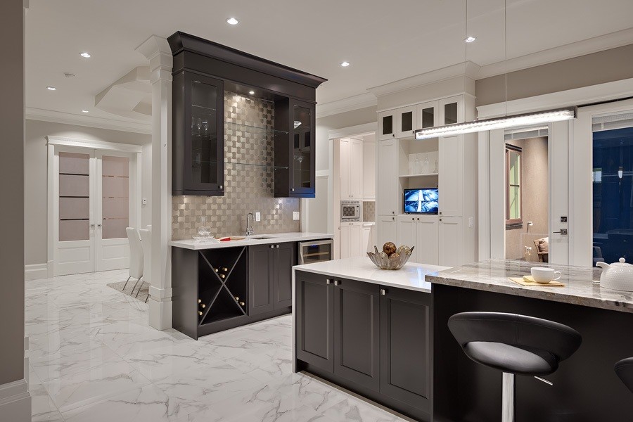 Photo of an expansive traditional u-shaped wet bar in Vancouver with a submerged sink, shaker cabinets, brown cabinets, marble worktops, multi-coloured splashback, metal splashback and porcelain flooring.