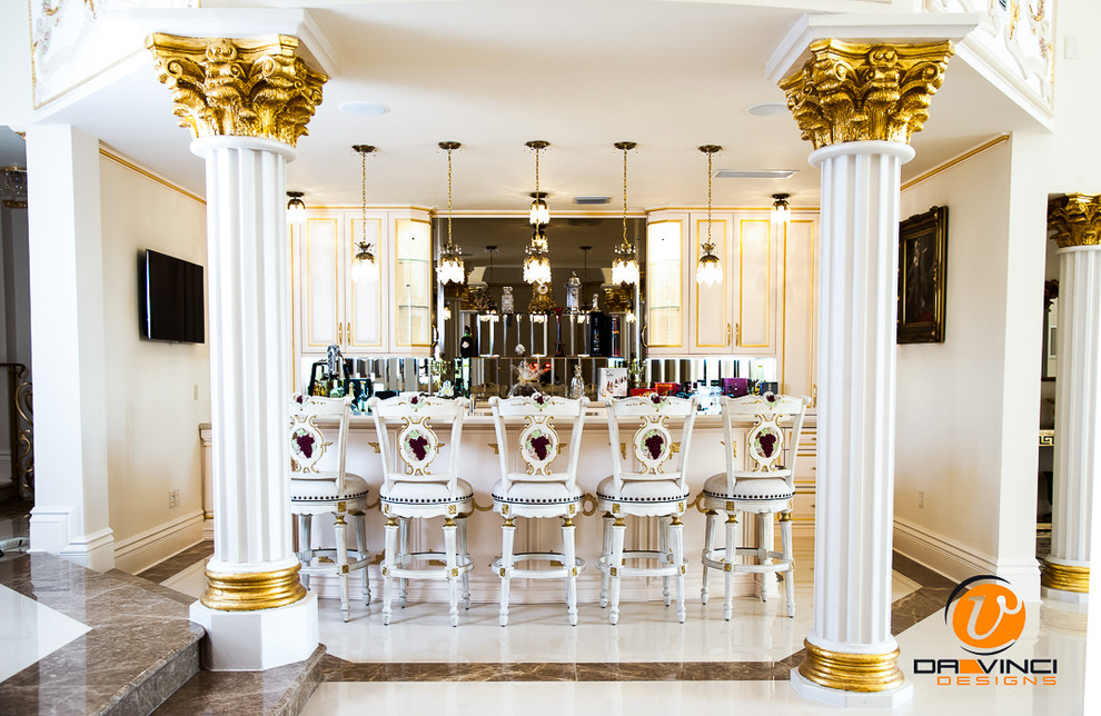 Aménagement d'un grand bar de salon linéaire classique avec des portes de placard blanches, des tabourets, un placard avec porte à panneau encastré, un plan de travail en granite et une crédence beige.