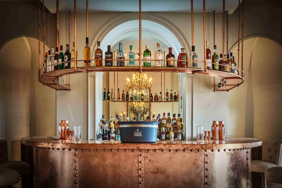 На фото: п-образный домашний бар в стиле лофт с барной стойкой, плоскими фасадами и зеркальным фартуком