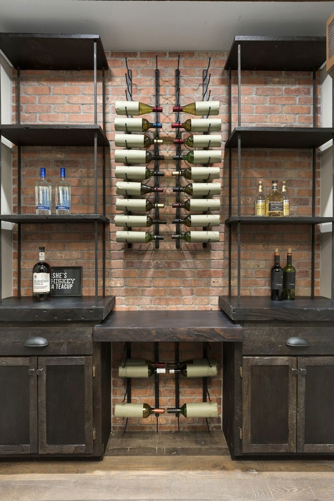 Cette image montre un bar de salon craftsman de taille moyenne avec des tabourets, une crédence marron, une crédence en brique, parquet foncé et un sol marron.