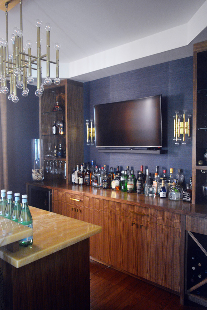 Idee per un bancone bar moderno di medie dimensioni con lavello da incasso, ante lisce, ante in legno scuro, top in onice, paraspruzzi blu e parquet scuro
