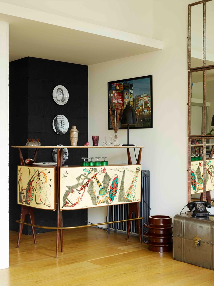 Esempio di un grande angolo bar con lavandino boho chic con ante gialle, top in marmo, paraspruzzi nero, paraspruzzi in mattoni, pavimento in legno massello medio, pavimento marrone e top bianco