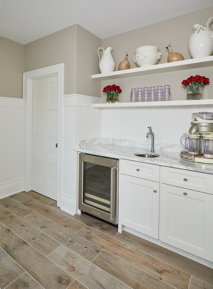 Mid-sized eclectic single-wall medium tone wood floor and gray floor wet bar photo in Grand Rapids with an undermount sink, recessed-panel cabinets, white cabinets, granite countertops, white backsplash, shiplap backsplash and white countertops