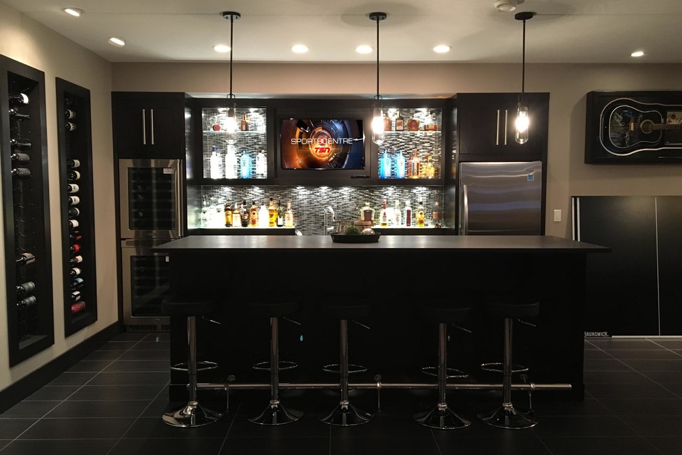 This is an example of a medium sized contemporary galley home bar in Calgary with a submerged sink, dark wood cabinets, granite worktops, multi-coloured splashback, glass tiled splashback and ceramic flooring.