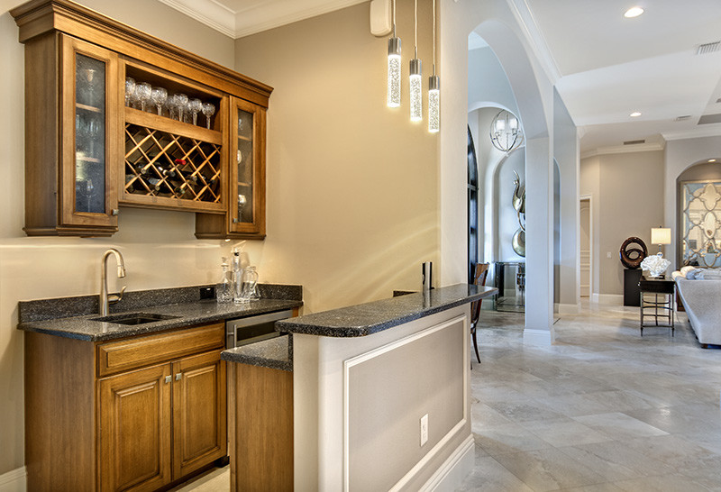 Photo of a classic galley wet bar in Tampa with a built-in sink, raised-panel cabinets and medium wood cabinets.