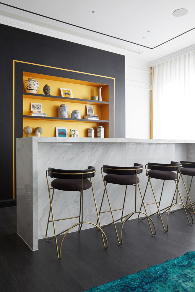 Immagine di un angolo bar minimal con paraspruzzi arancione, parquet scuro, pavimento nero e top bianco