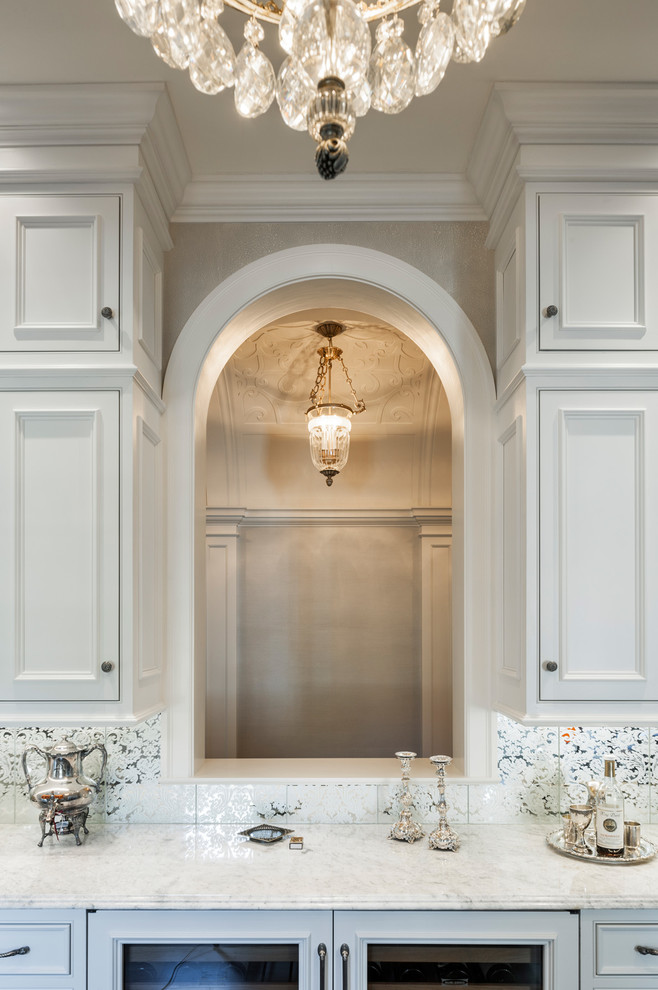 Photo of an expansive classic single-wall wet bar in Philadelphia with a submerged sink, beaded cabinets, white cabinets, marble worktops, white splashback and dark hardwood flooring.