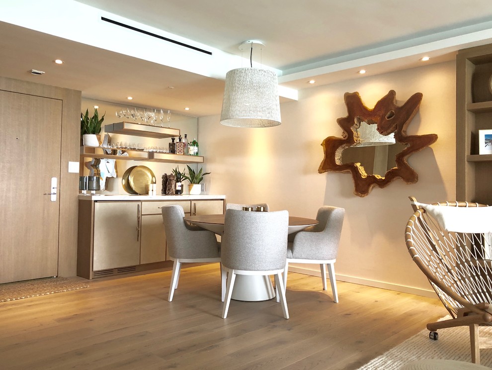 Medium sized modern single-wall home bar in Miami with no sink, flat-panel cabinets, beige cabinets, marble worktops, mirror splashback, light hardwood flooring and beige floors.
