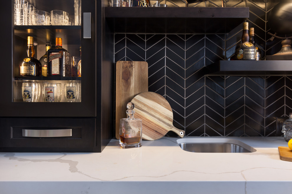 Design ideas for a small contemporary galley wet bar in Other with a submerged sink, recessed-panel cabinets, black cabinets, engineered stone countertops, black splashback, ceramic splashback, porcelain flooring, brown floors and white worktops.
