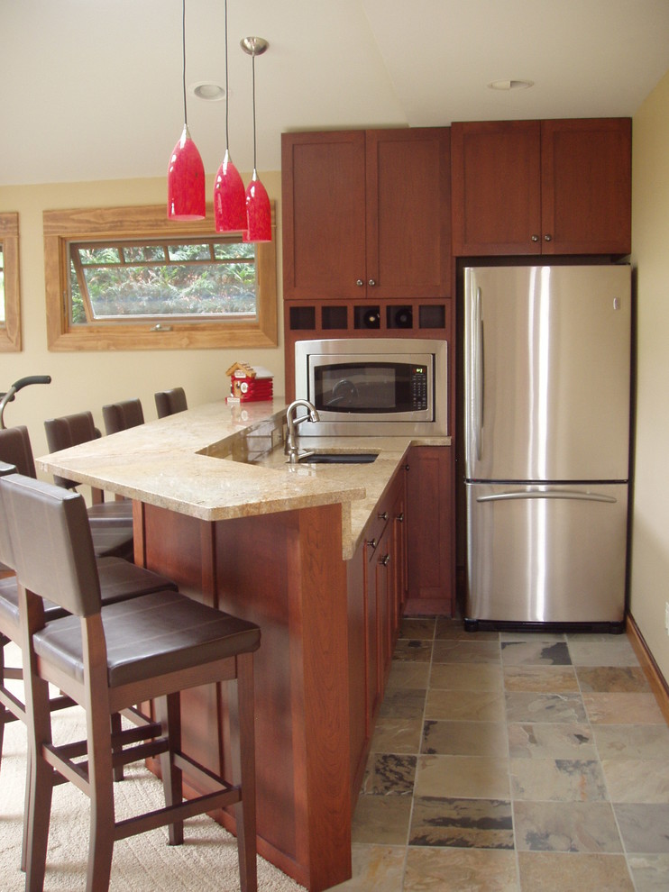 Immagine di una cucina a L moderna di medie dimensioni con lavello sottopiano, ante in stile shaker, ante in legno bruno e top in granito