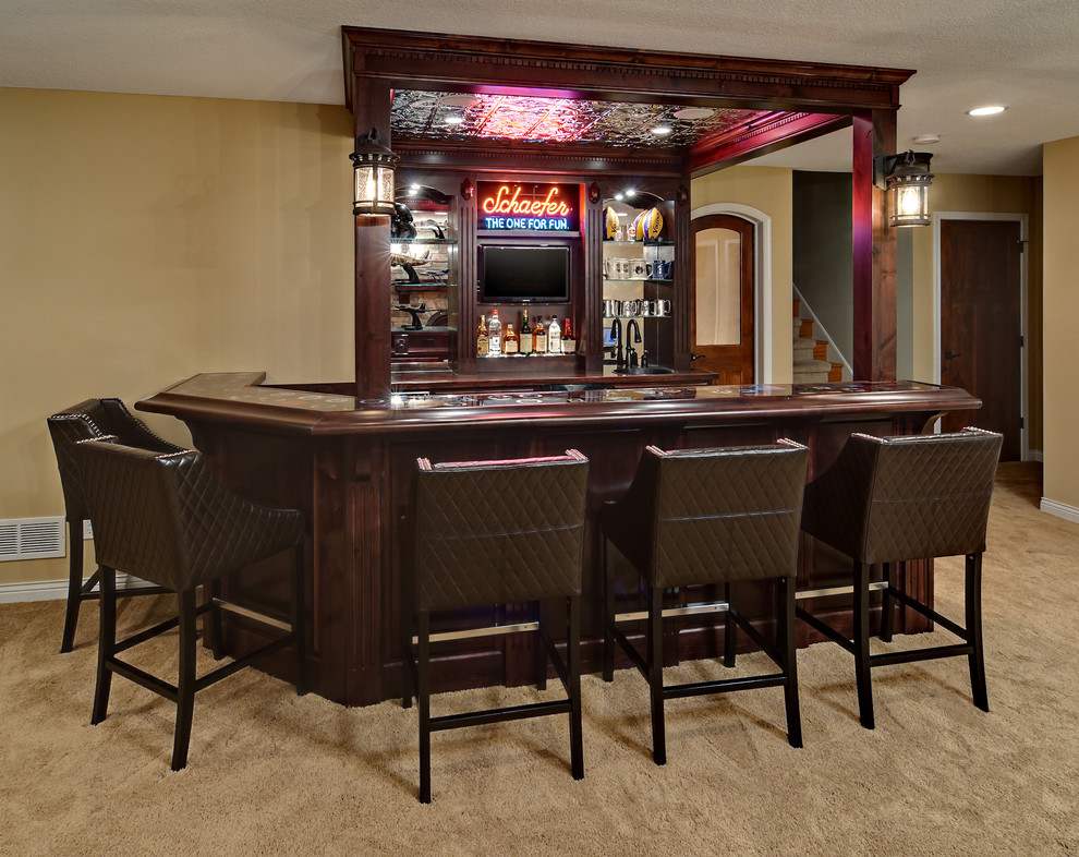 На фото: домашний бар в классическом стиле с ковровым покрытием, барной стойкой, темными деревянными фасадами и зеркальным фартуком