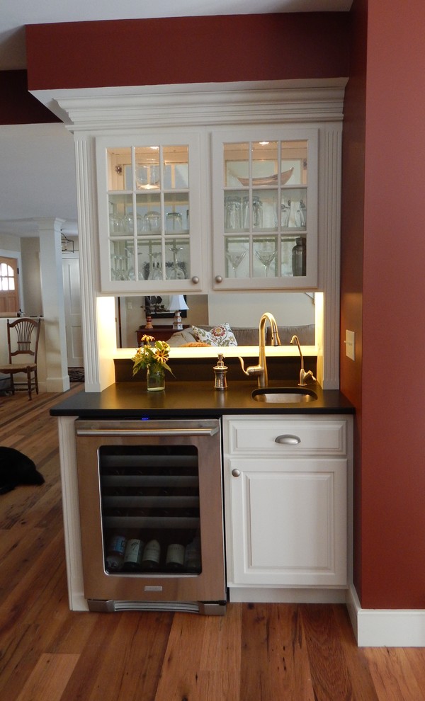 Exempel på en klassisk hemmabar med vask, med en undermonterad diskho, luckor med upphöjd panel, vita skåp, granitbänkskiva och mellanmörkt trägolv