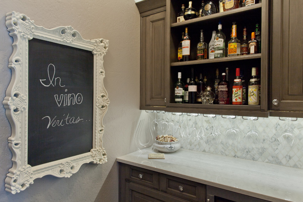This is an example of a small classic home bar in Other with marble splashback.