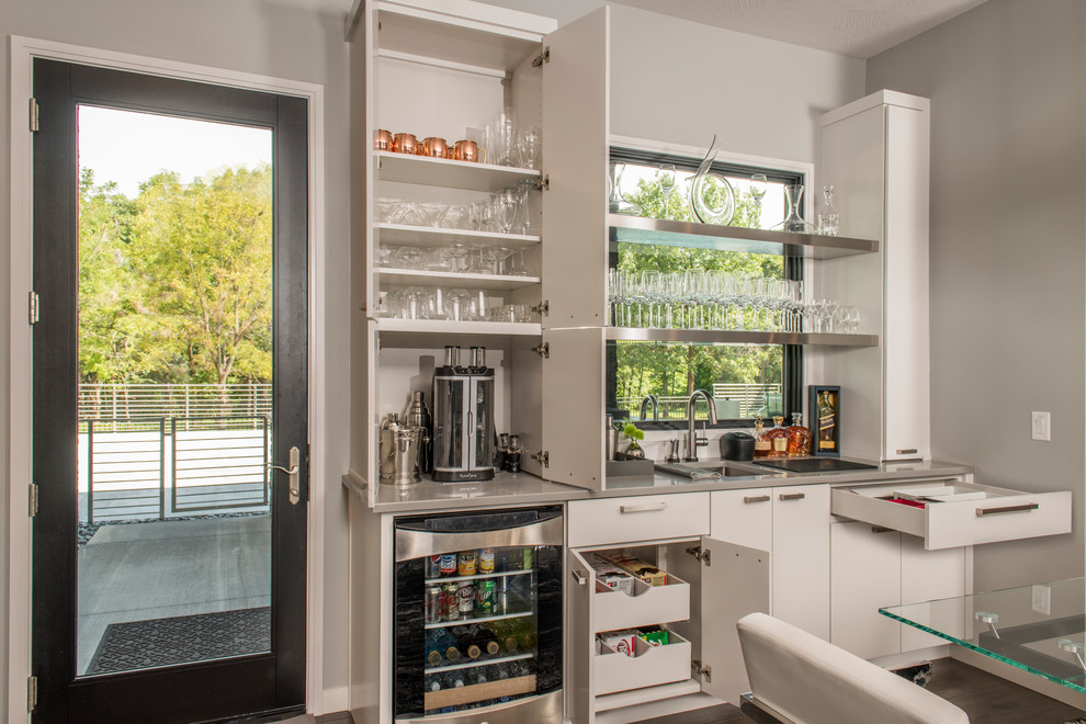 Medium sized contemporary single-wall wet bar in Other with white cabinets, a submerged sink and flat-panel cabinets.
