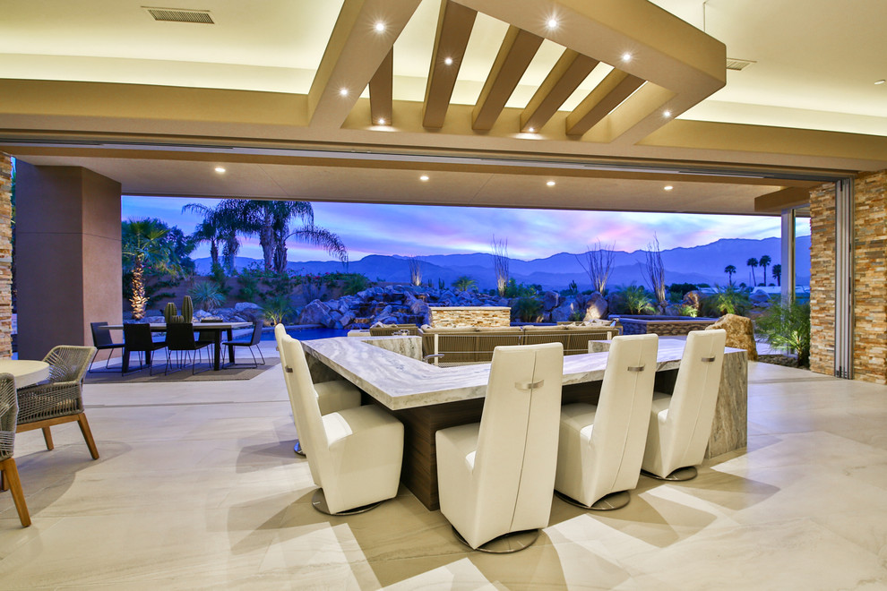 Exemple d'un très grand bar de salon tendance en U avec un plan de travail en granite, un sol en carrelage de porcelaine, des tabourets et un sol beige.