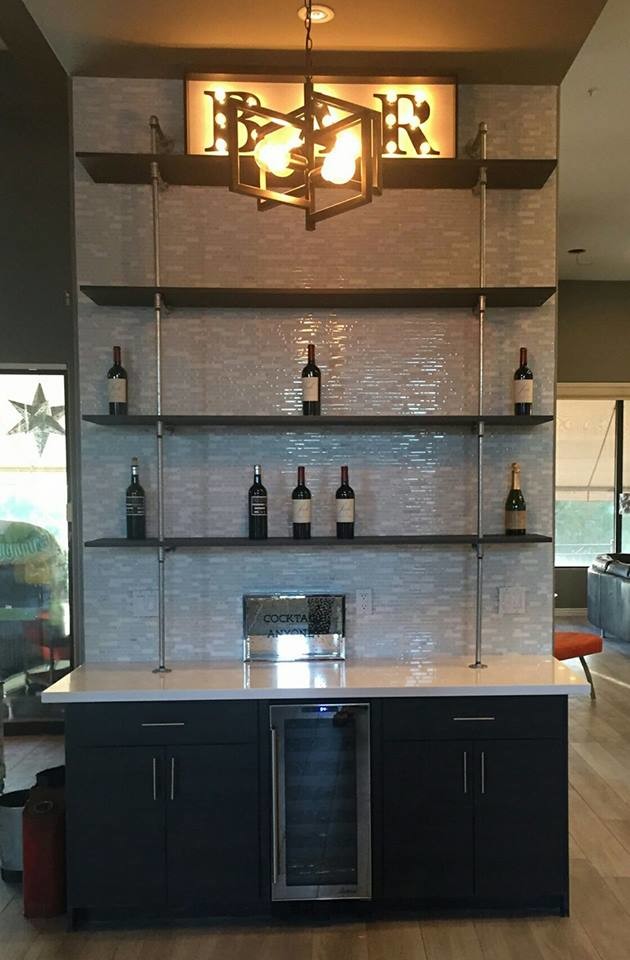 Inspiration for a small modern single-wall wet bar in Phoenix with flat-panel cabinets, brown cabinets, no sink, engineered stone countertops, grey splashback, matchstick tiled splashback and light hardwood flooring.