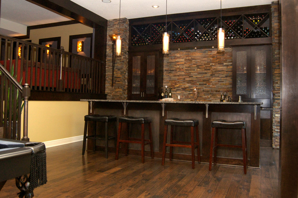 Modern inredning av en stor grå linjär grått hemmabar med stolar, med en undermonterad diskho, släta luckor, skåp i mörkt trä, brunt stänkskydd, stänkskydd i stenkakel, mörkt trägolv, brunt golv och granitbänkskiva