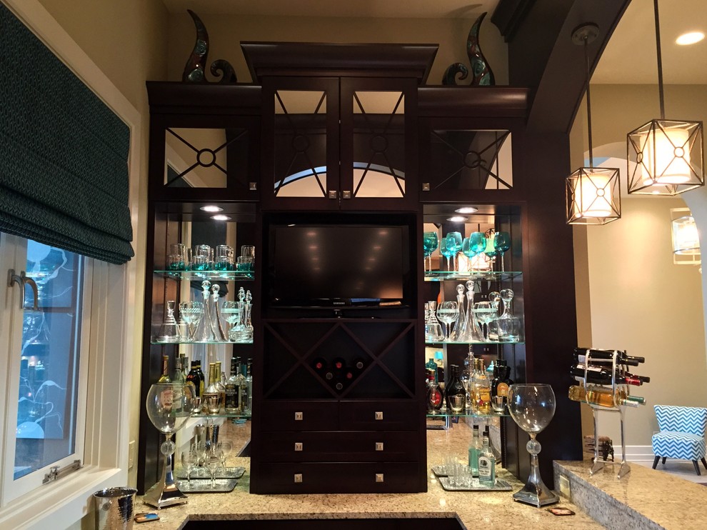 Inspiration for a large traditional u-shaped wet bar in Other with flat-panel cabinets, black cabinets, granite worktops, travertine flooring, beige floors and a submerged sink.
