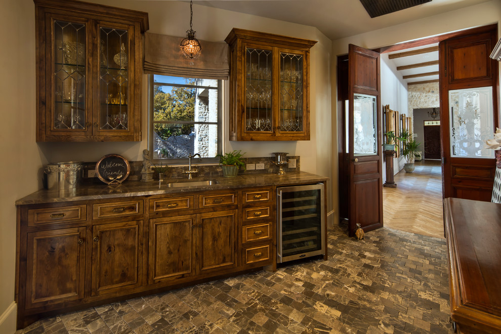 Foto på en mellanstor lantlig bruna linjär hemmabar med vask, med en undermonterad diskho, luckor med infälld panel, skåp i mörkt trä, marmorbänkskiva och marmorgolv