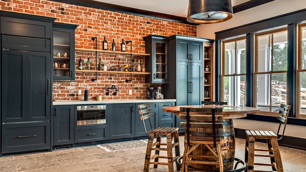 Photo of a large farmhouse single-wall breakfast bar in Nashville with shaker cabinets, black cabinets, red splashback, brick splashback, white worktops, travertine flooring and brown floors.