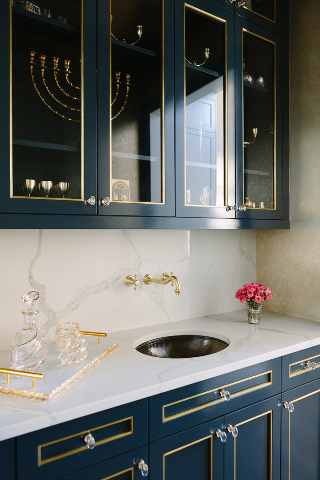 Inspiration för mellanstora klassiska linjära vitt hemmabarer med vask, med en undermonterad diskho, blå skåp, vitt stänkskydd, luckor med glaspanel, marmorbänkskiva och stänkskydd i marmor