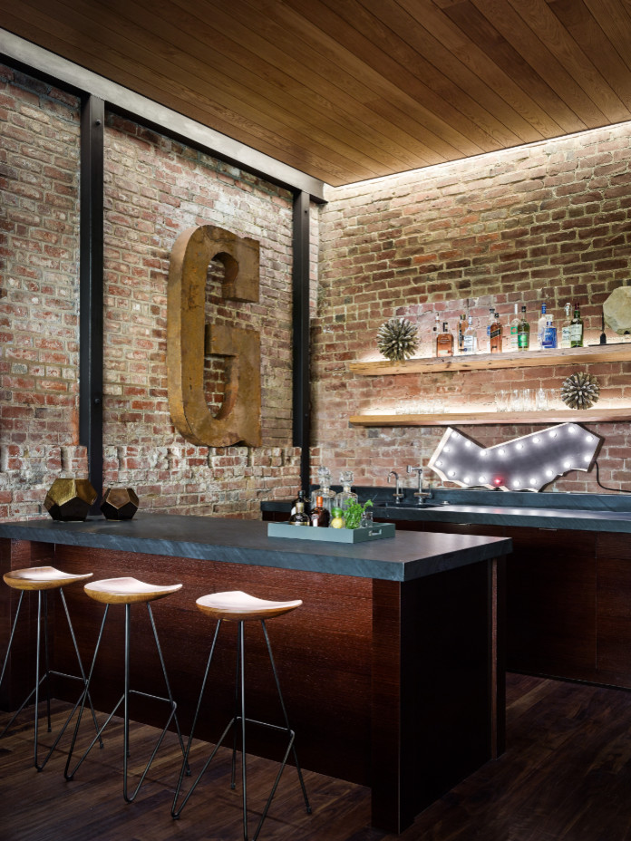 Example of a large urban single-wall dark wood floor and brown floor seated home bar design in San Francisco with an undermount sink, dark wood cabinets, concrete countertops, red backsplash and brick backsplash