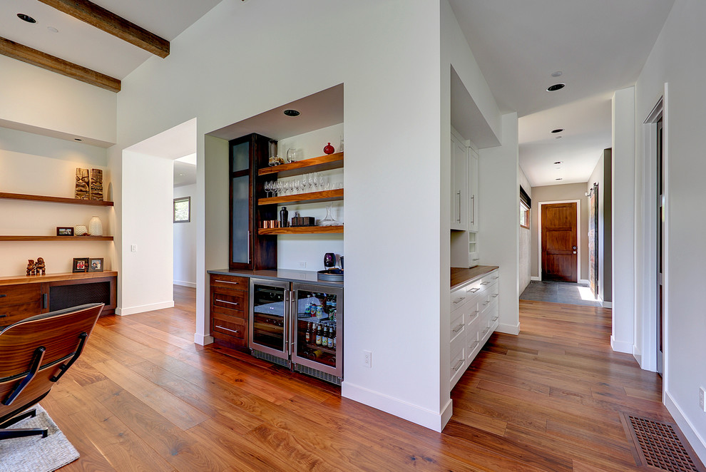Example of a small trendy single-wall medium tone wood floor wet bar design in Portland with no sink, shaker cabinets, medium tone wood cabinets and solid surface countertops