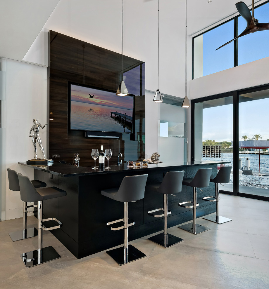 Example of a trendy l-shaped beige floor seated home bar design in Miami with black cabinets, brown backsplash and black countertops