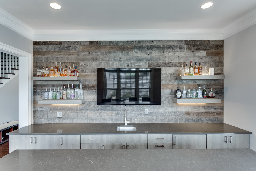 Example of a mid-sized minimalist galley medium tone wood floor seated home bar design in DC Metro with an undermount sink, quartz countertops and gray backsplash