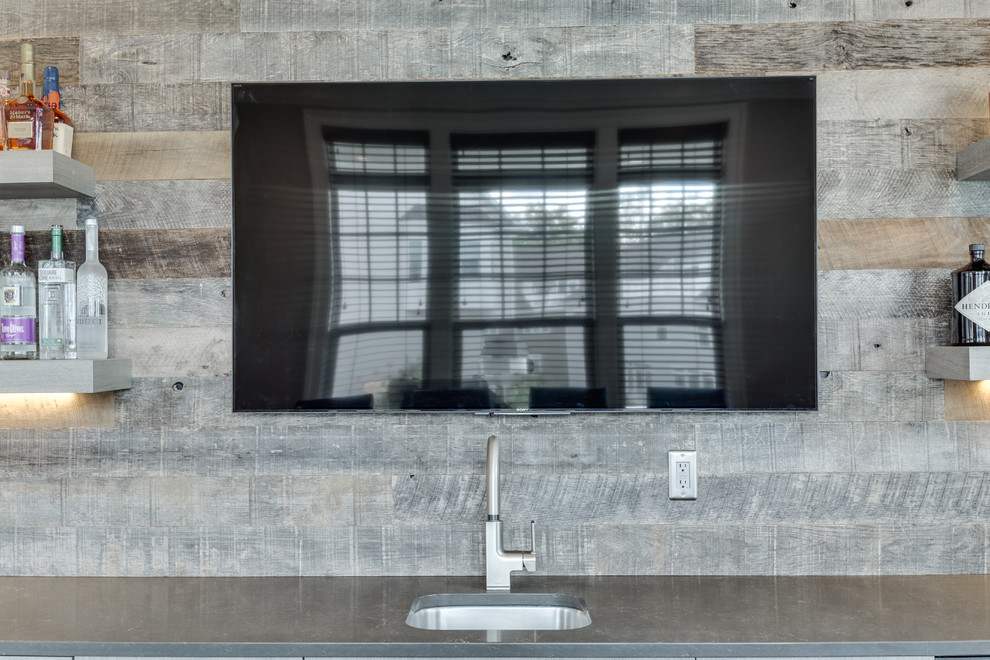 Esempio di un bancone bar moderno di medie dimensioni con lavello sottopiano, top in quarzo composito, paraspruzzi grigio e pavimento in legno massello medio