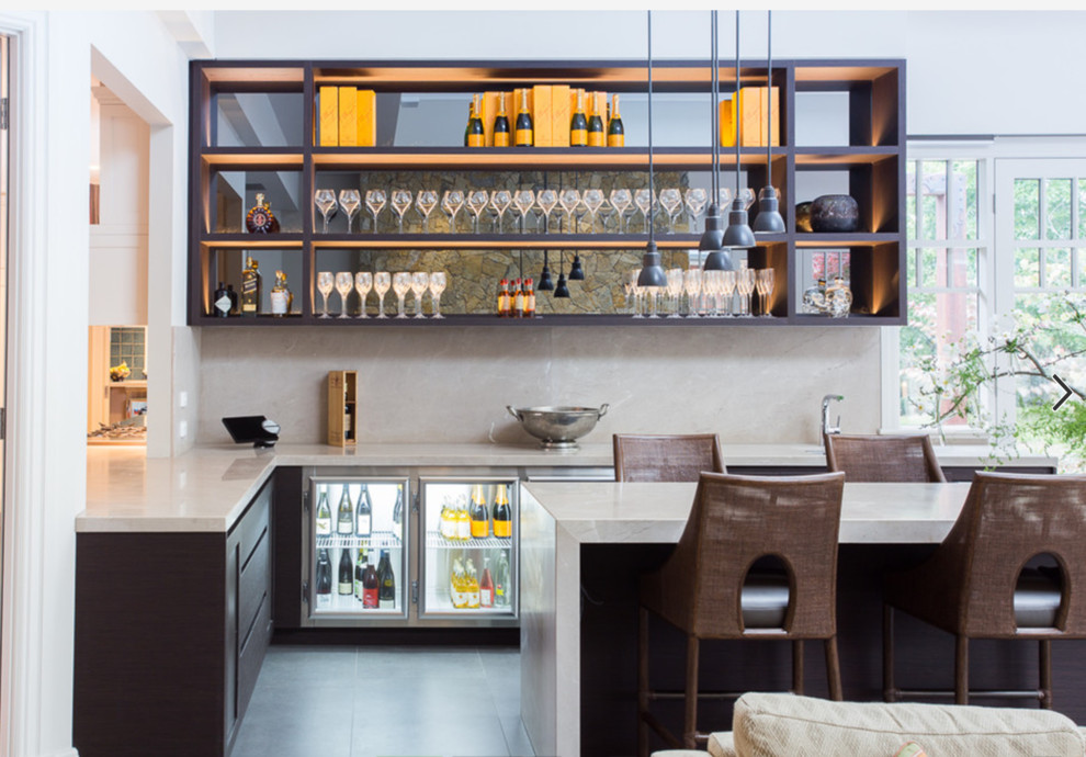 Immagine di un bancone bar design con lavello sottopiano, nessun'anta, ante nere, paraspruzzi beige e pavimento grigio