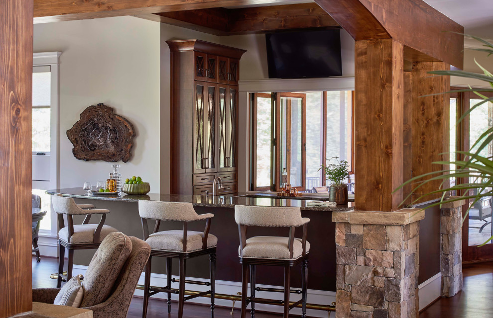 Ejemplo de bar en casa con barra de bar rural con puertas de armario de madera oscura, suelo de madera en tonos medios y encimeras marrones