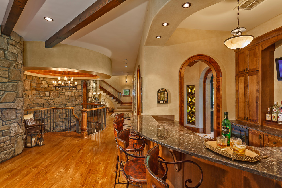 Example of a large mountain style light wood floor home bar design in Other