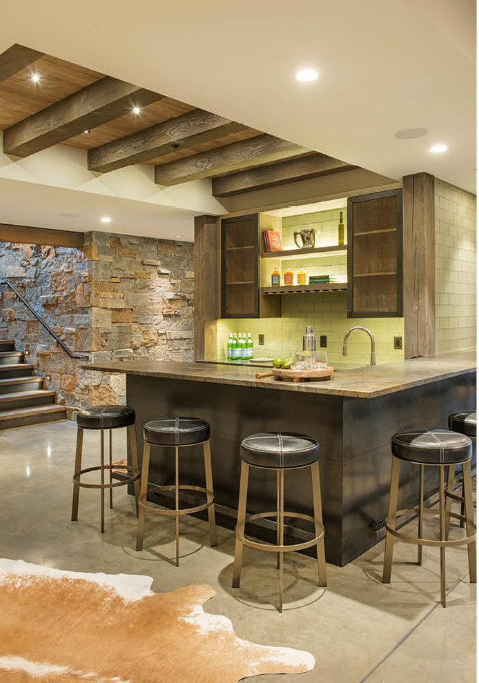Mittelgroße Rustikale Hausbar in L-Form mit Bartheke, Küchenrückwand in Grün, Betonboden, grauem Boden, Rückwand aus Metrofliesen und Glasfronten in Sonstige