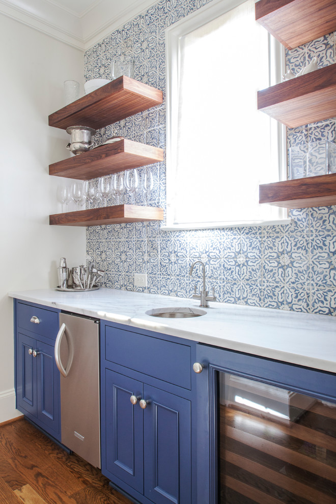 Photo of a large classic single-wall wet bar in Charlotte with a submerged sink, blue cabinets, multi-coloured splashback and medium hardwood flooring.