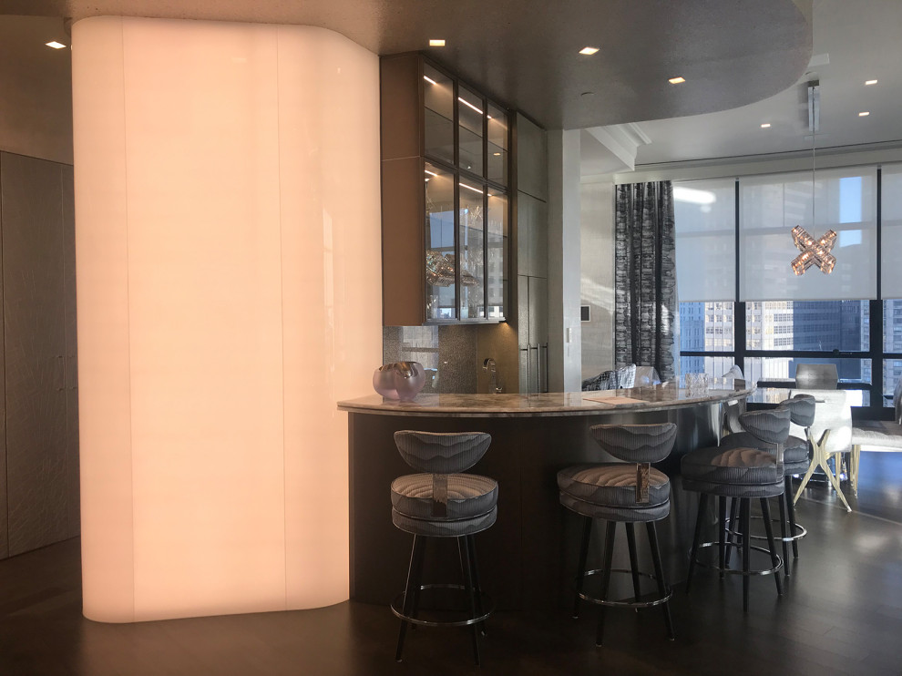This is an example of a small traditional u-shaped breakfast bar in New York with glass-front cabinets, dark wood cabinets, onyx worktops, grey splashback, glass sheet splashback, dark hardwood flooring, brown floors and beige worktops.