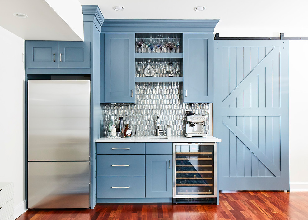 This is an example of a medium sized beach style single-wall wet bar in Philadelphia with a submerged sink, shaker cabinets, blue cabinets, metal splashback, medium hardwood flooring and white worktops.