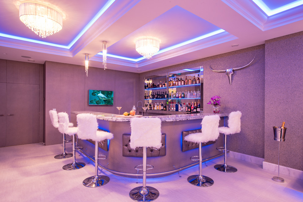 Cette image montre un bar de salon design en L de taille moyenne avec des tabourets, un placard sans porte, une crédence miroir et un sol gris.