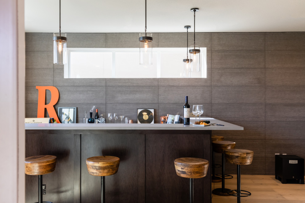 Mittelgroße Moderne Hausbar in L-Form mit Bartresen, Unterbauwaschbecken und hellem Holzboden in Denver