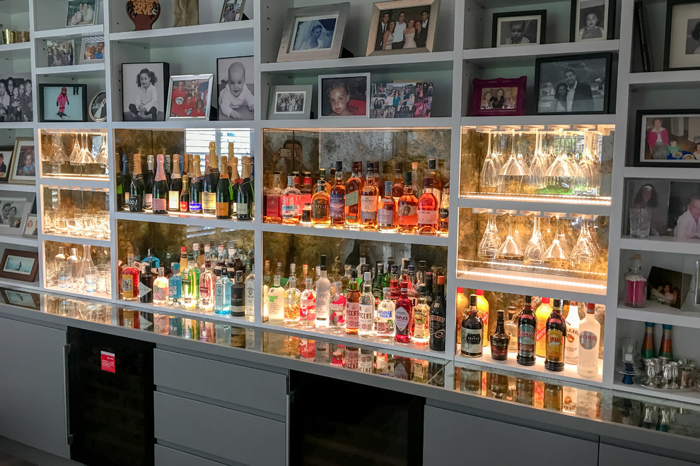 Foto di un grande angolo bar design con ante lisce, ante grigie, top in vetro, paraspruzzi multicolore e paraspruzzi a specchio