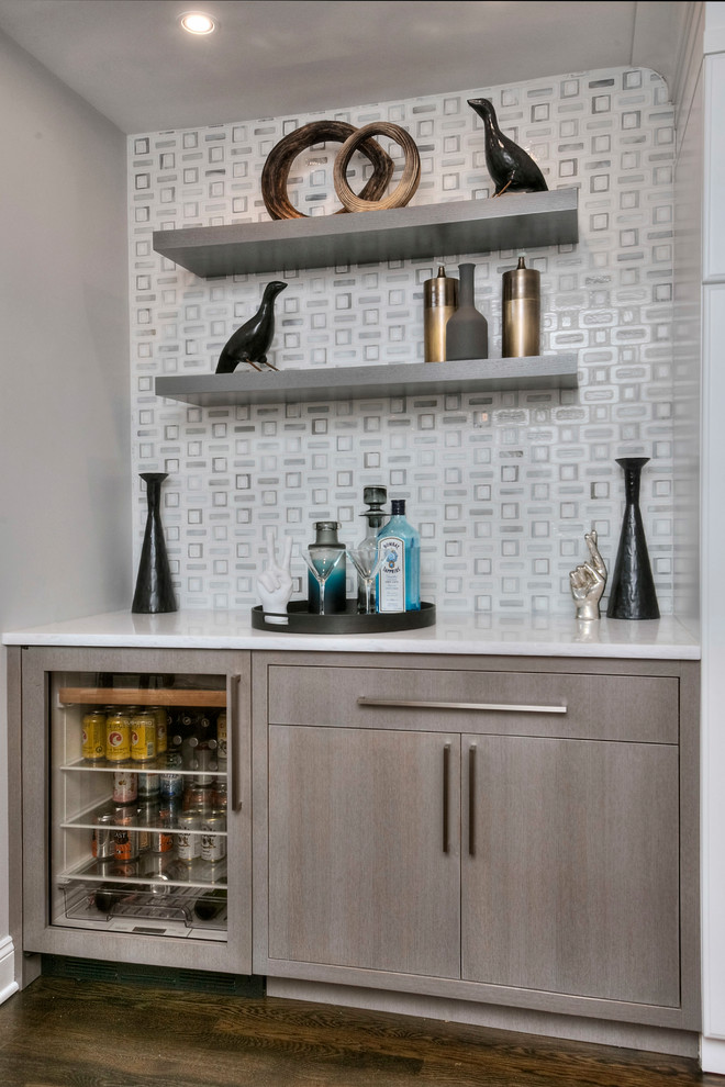 Example of a mid-sized transitional single-wall dark wood floor and brown floor wet bar design in Other with quartzite countertops, white backsplash, marble backsplash, no sink, flat-panel cabinets, medium tone wood cabinets and white countertops