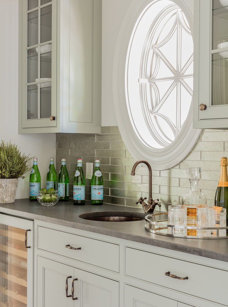Traditional wet bar in Boston with a submerged sink, beaded cabinets, grey cabinets and metal splashback.