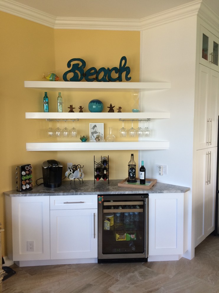 Medium sized coastal single-wall wet bar in Miami with recessed-panel cabinets, white cabinets, marble worktops, ceramic flooring and beige floors.