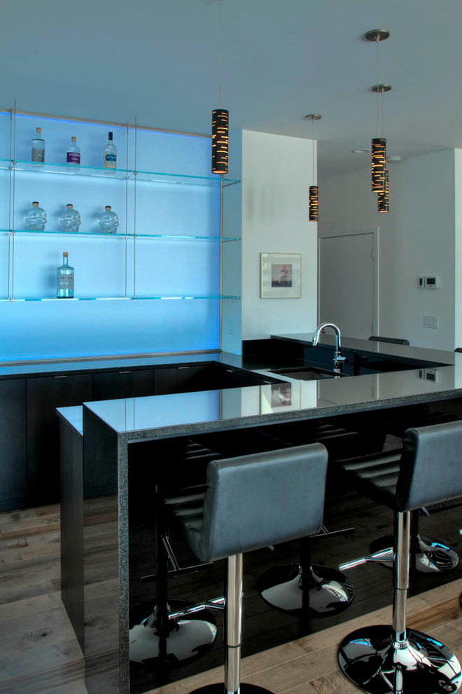 Cette photo montre un grand bar de salon moderne en U avec un sol en bois brun, des tabourets, un placard à porte plane et un sol marron.