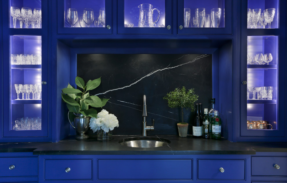 Ispirazione per un piccolo angolo bar con lavandino chic con lavello sottopiano, ante lisce, ante blu, top in marmo, paraspruzzi nero, paraspruzzi in lastra di pietra e parquet scuro
