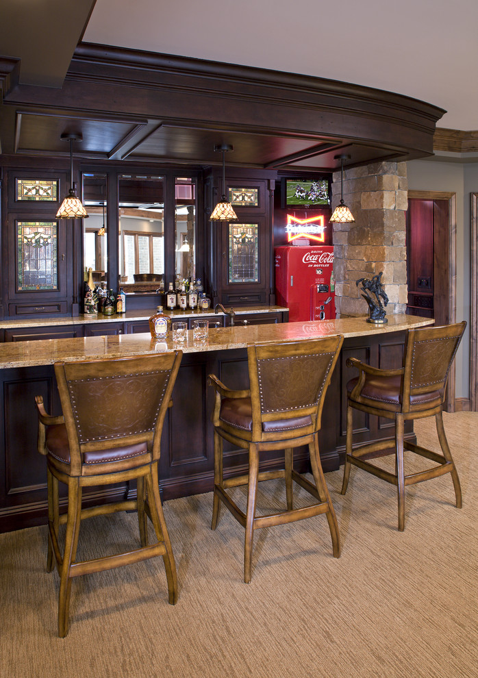 Large traditional galley breakfast bar in Minneapolis with raised-panel cabinets, dark wood cabinets, granite worktops, carpet and a submerged sink.