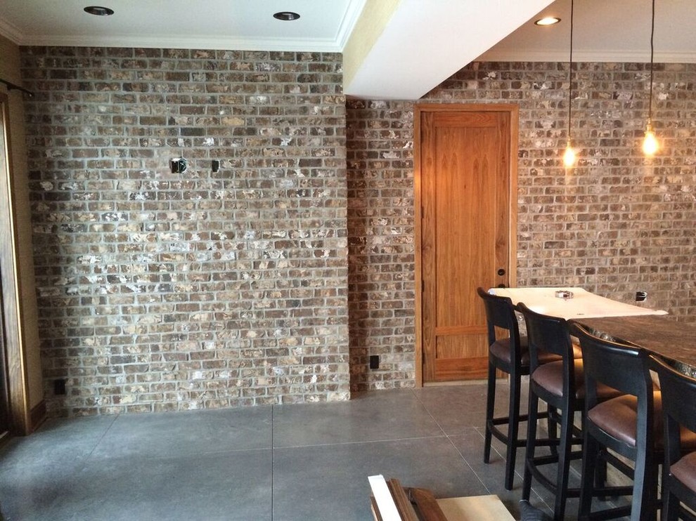 Imagen de bar en casa con barra de bar lineal industrial grande con armarios abiertos, salpicadero de ladrillos, suelo de cemento y suelo gris