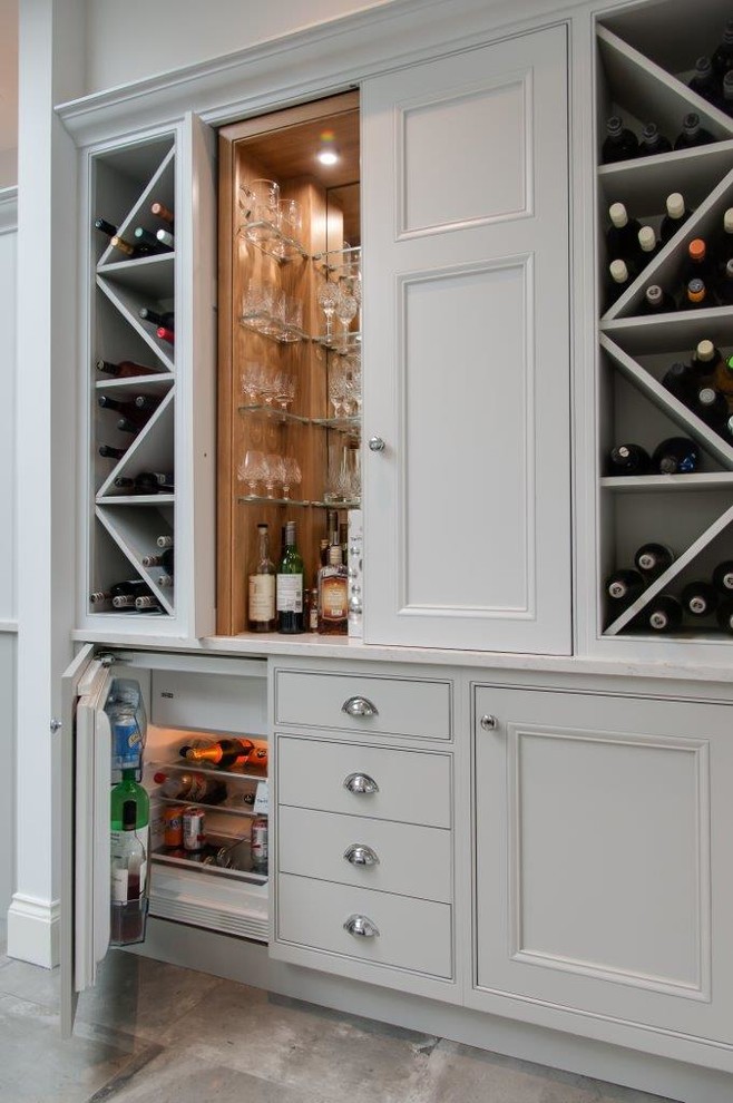 Inspiration for a medium sized classic single-wall home bar in Hertfordshire with no sink, recessed-panel cabinets, grey cabinets and grey floors.